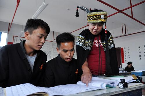 7月10日,毕节彝文双语职业学校的老师(右)在指导学生认识彝族文字。新华社发(杨文斌摄) \